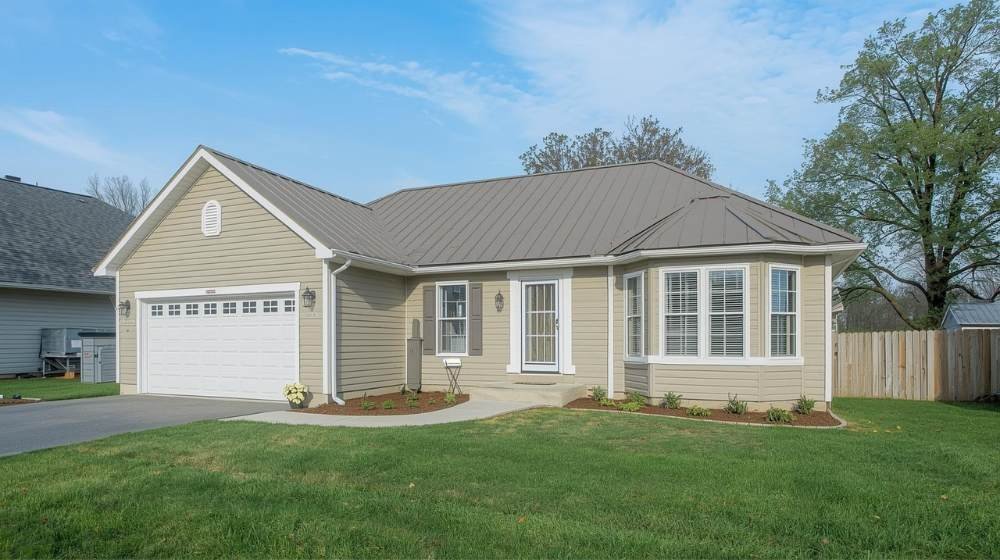 A cozy home with a gable roof and welcoming front porch, emphasizing the advantages and disadvantages of gable roofs, such as increased attic space and potential for higher construction costs due to complex design.