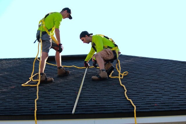 Two workers performing a commercial roof inspection on a flat roof in Brooklyn