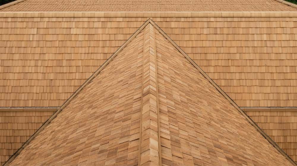 Close-up view of a rich-toned wood shake roof, highlighting the natural texture in the Wood Shake vs Wood Shingle roofing styles.