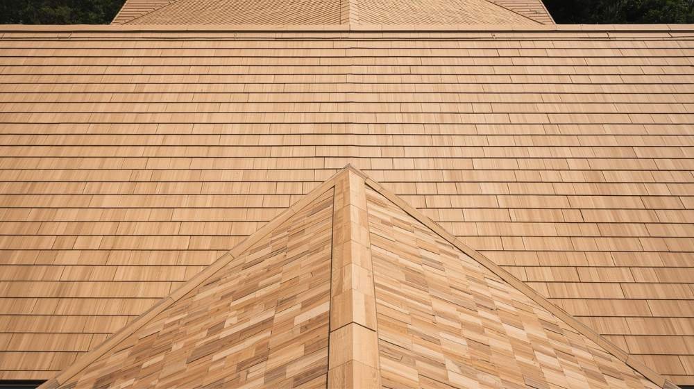 Sleek and uniform wood shingle roof with evenly spaced shingles, offering a smooth finish in the Wood Shake vs Wood Shingle debate.