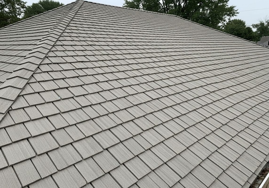 Close-up view of fiber cement shake roof tiles on a residential roof, showing textured surface and uniform layout.
