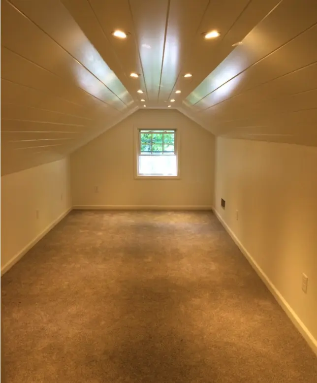 Attic conversion with recessed ceiling lights and natural light window for bright loft space